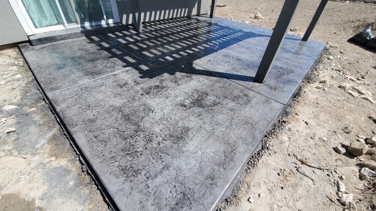 Grey stamped concrete patio under pergola in Utah